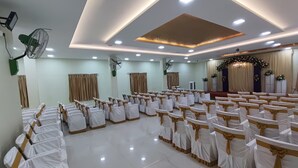 A spacious hall with rows of chairs, ceiling fans, and recessed lighting. - Nalli Plaza (Omalur)