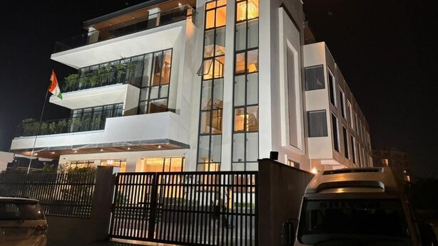 A modern hotel with a multi-story structure, large windows, and a flag on the left side. - KRISHNA ANANDAM PALACE (Mathura)