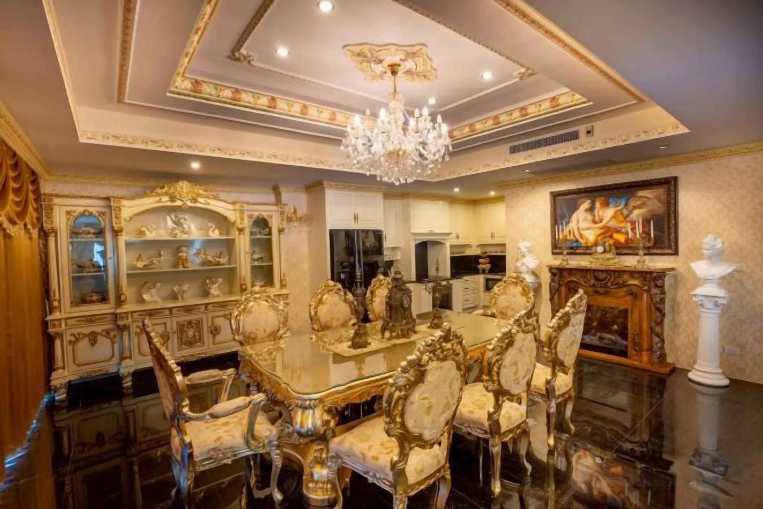 A luxurious dining room with ornate furniture, a chandelier, and classical decor.
