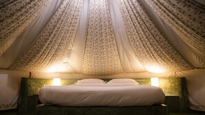 A tent-style room with a bed, two bedside lamps, and patterned curtains. - Virama Gokarna (Gokarna)