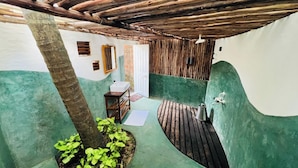 A compact bathroom with a wooden ceiling, a sink, and a shower area. - Virama Gokarna (Gokarna)