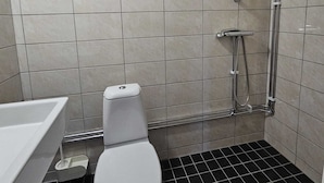 A bathroom with a toilet, a shower, and a sink. - Nox Hotel (Huddinge)