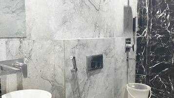 Un baño con lavamanos, inodoro y ducha blancos.