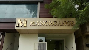 A modern building with a sign reading "MANORGANGE." - Hotel Manor Ganges (Varanasi)