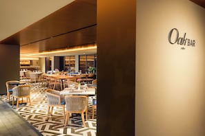 L'intérieur d'un restaurant, avec des tables, des chaises et un coin bar.
