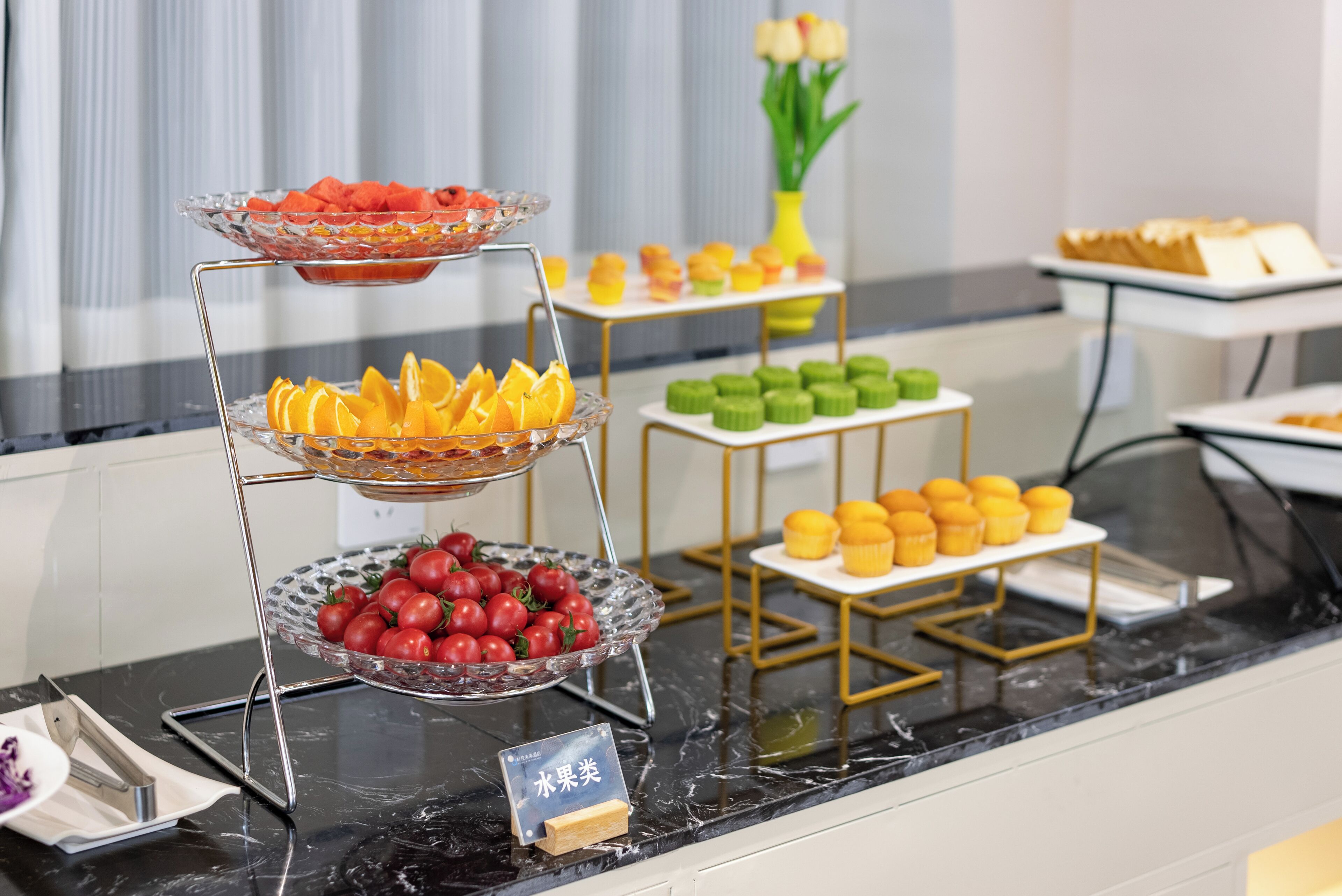 A buffet with various fruits and pastries.