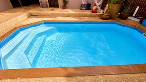 A rectangular swimming pool with a wooden deck surrounding it. - Charming Guest Room in Central Pa Tong, Thailand (Pa Tong)