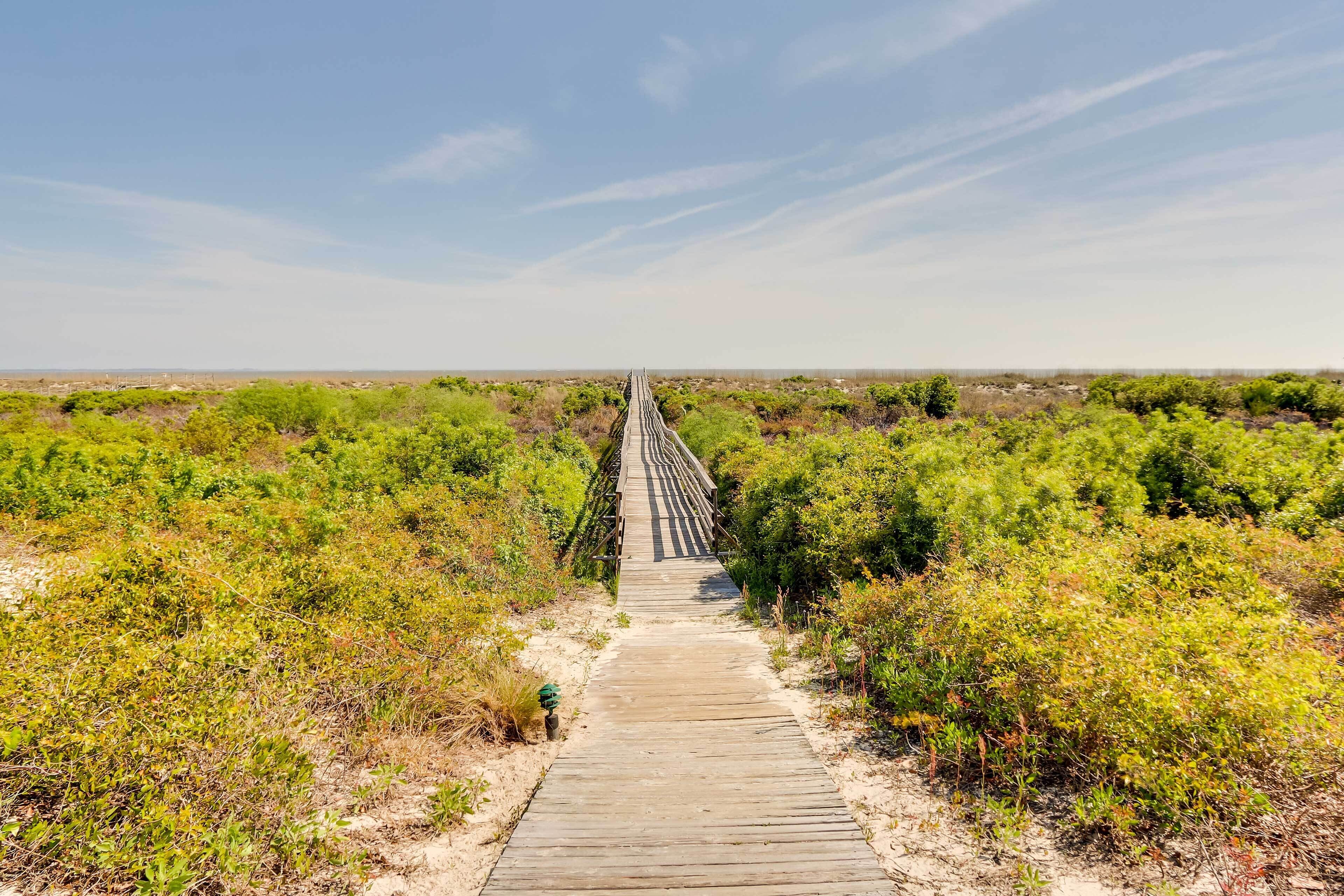 A wooden boardwalk extending into a natural landscape.