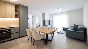 A modern apartment with a kitchen, dining area, and living room.