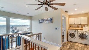 A spacious laundry room with a view of the lake, a ceiling fan, and a sign that reads "GO JUMP IN THE LAKE". - Waterfront Clear Lake Home w/ Game Room & Deck! (Upper Lake)