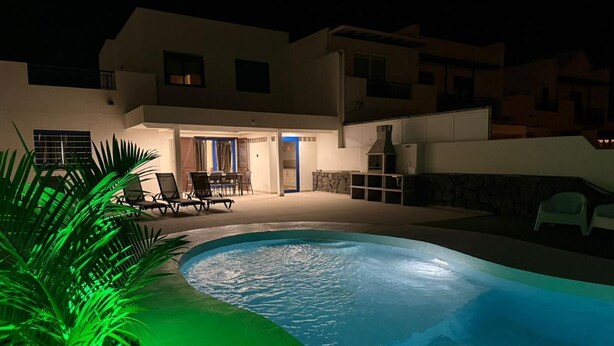 A swimming pool with a patio area, a dining table, and chairs. - Holiday Home 'Oasis 138' with Mountain View, Private Pool and Wi-Fi (Playa Blanca)