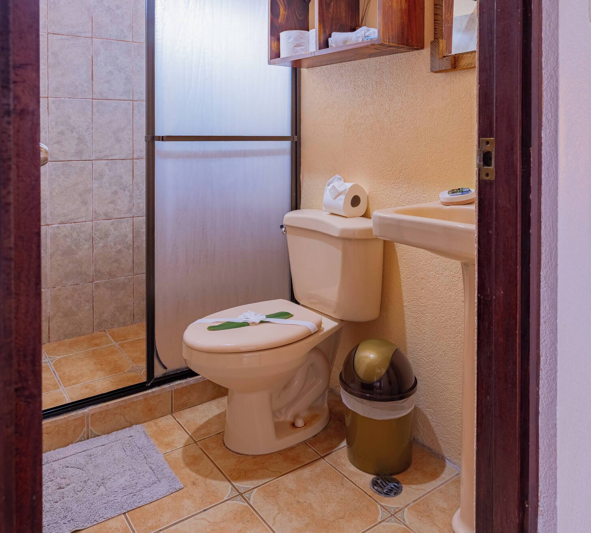 Une petite salle de bain avec des toilettes, un lavabo et une poubelle.