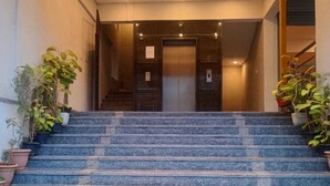 Μια σειρά από πέτρινα σκαλοπάτια που οδηγούν σε έναν ανελκυστήρα μέσα σε ένα κτίριο.