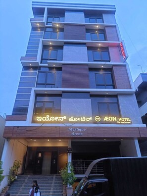 Un hotel de varios pisos con un diseño moderno, que cuenta con balcones, ventanas amplias y un letrero llamativo del HOTEL AEON.