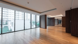 A spacious, modern interior with large windows, wooden flooring, and a neutral color palette. - Meydan Apartment Sleeps 4 With Great Amenities (Dubai)