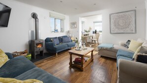 A living room with a sofa, a coffee table, and a fireplace. - Little Tresevens is a generously sized detached home (Polzeath)