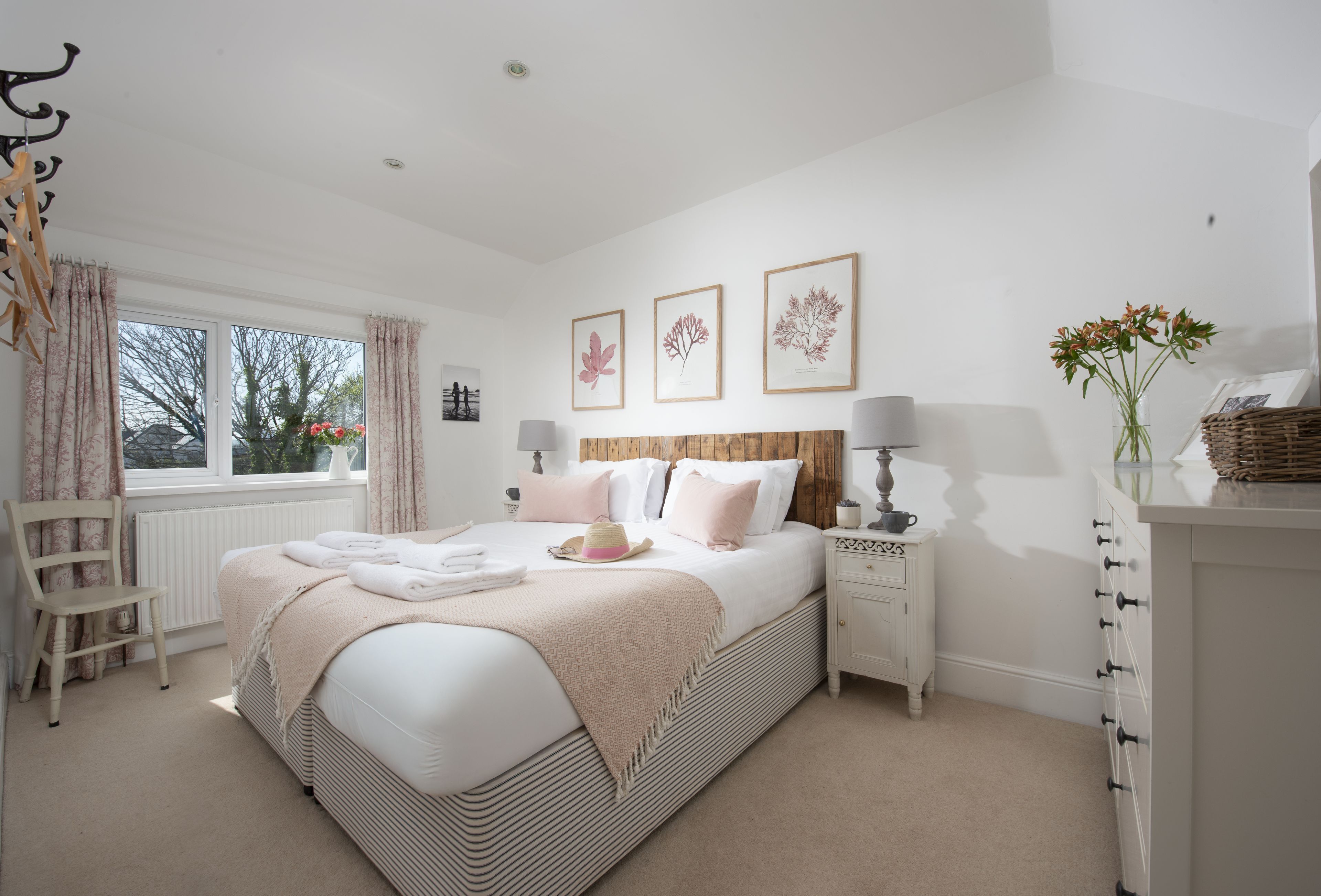 A bedroom with a bed, bedside tables, a chair, and a window with curtains.