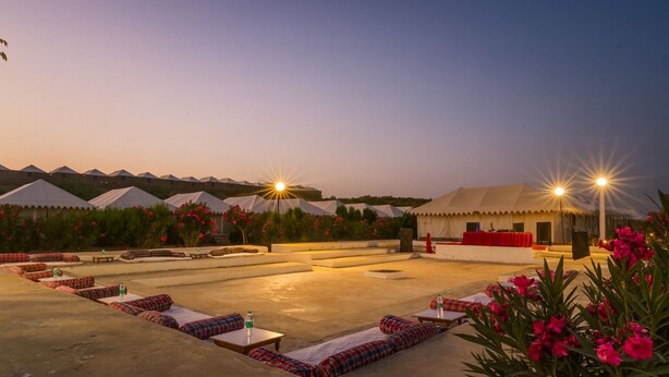 Terraza en la azotea con zonas de estar, carpas y escenario para eventos.