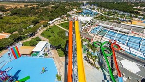 A water park with a tall water slide, multiple water attractions, and a pool area. - Algardia Marina Parque by Garvetur (Loulé)