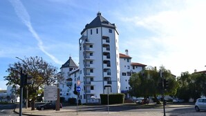 A multi-story building with a distinctive tower-like structure, a crosswalk, and a traffic sign indicating a right turn. - Algardia Marina Parque by Garvetur (Loulé)