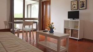 A hotel room with a bed, a desk, a chair, a TV, and a window with curtains. - Algardia Marina Parque by Garvetur (Loulé)