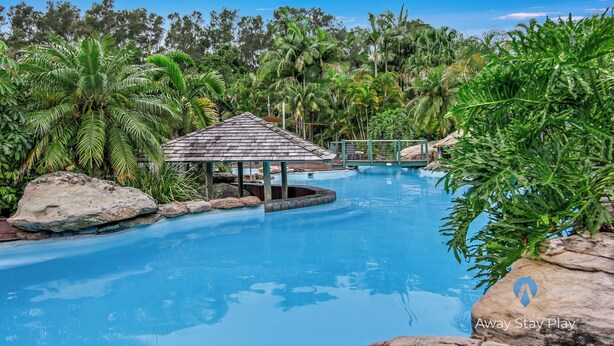 A pool area with a gazebo, surrounded by tropical vegetation and rocks. - Diggers Beach Studio - In Aanuka Beach Resort. Pools, Spa, Tennis, Restaurant (Coffs Harbour)