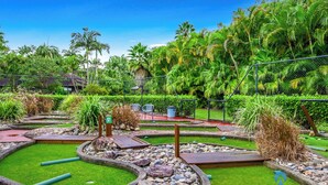A landscaped garden with pathways, rocks, and tropical plants. - Diggers Beach Studio - In Aanuka Beach Resort. Pools, Spa, Tennis, Restaurant (Coffs Harbour)