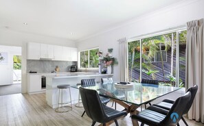 Una cocina moderna con armarios blancos, encimera de mármol y horno empotrado.