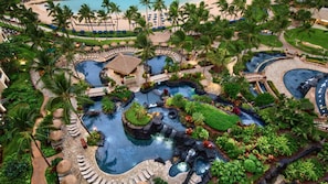 Un complexe hôtelier doté de plusieurs piscines, de palmiers et d’une plage.