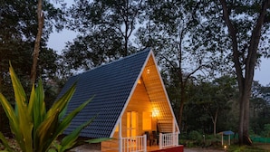 A small, triangular wooden cabin with a porch and a single visible room. - Dandeli Inn Resort  (Dandeli)