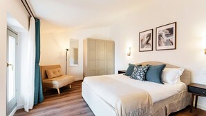 Une chambre à coucher avec un lit, une chaise, une armoire et deux tableaux encadrés accrochés au mur.