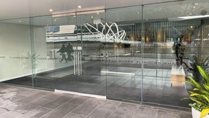 A modern interior with glass walls, a metal sculpture, and a tiled floor. - Luxurious Apartment With City Views and Yarra River (Melbourne)