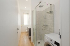 Een douche, een bidet, handdoeken, shampoo