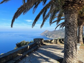 A stone pathway leading to a scenic overlook with a view of the sea and mountains. - Comfortable villa with private pool in a quiet location near St Florent (Oletta)