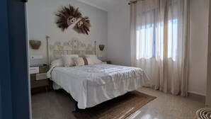 Ein Schlafzimmer mit einem Bett, einem Nachttisch, einer Wandleuchte und einem Wandbild.