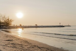 A beach with a stone wall and a pier extending into the water. - Charming 2-bedroom House in Hua Hin Soi 80,12-minute Walk to Beach (Hua Hin)