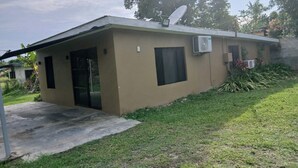A small, single-story building with a flat roof, a satellite dish, and an air conditioning unit. - Sigatoka Lodge (Sigatoka)