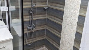 A shower with a glass door, a white sink, and a mirror. - Sigatoka Lodge (Sigatoka)