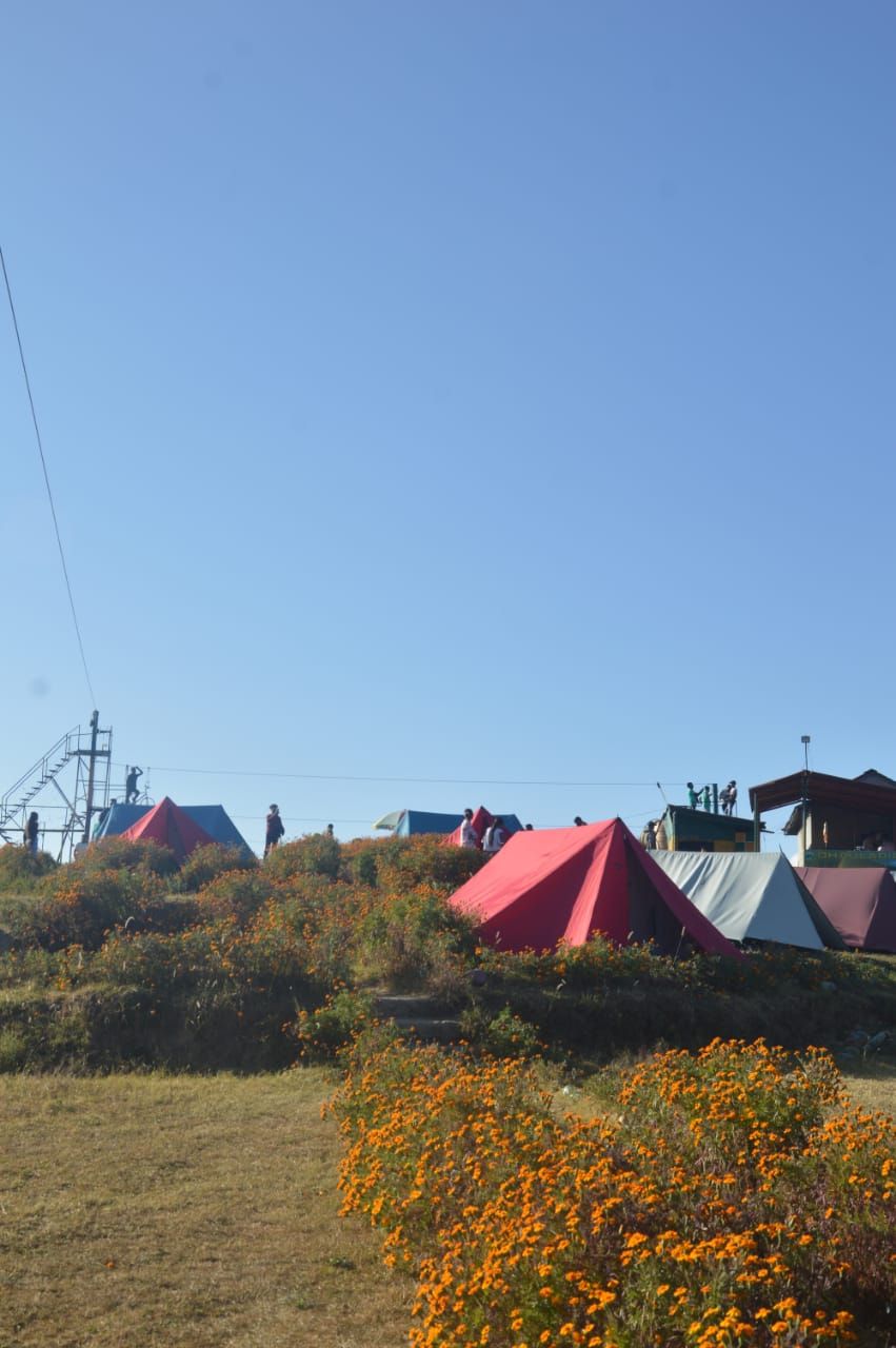 A campsite with tents and a staircase leading to a higher platform.