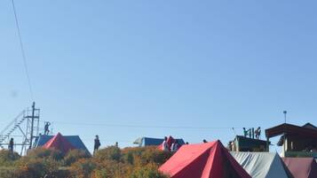 A campsite with tents and a staircase leading to a higher platform.