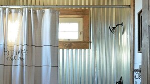 A bathroom with a shower, a toilet, and a window. - DhaulaPir Adventure (Chamba)