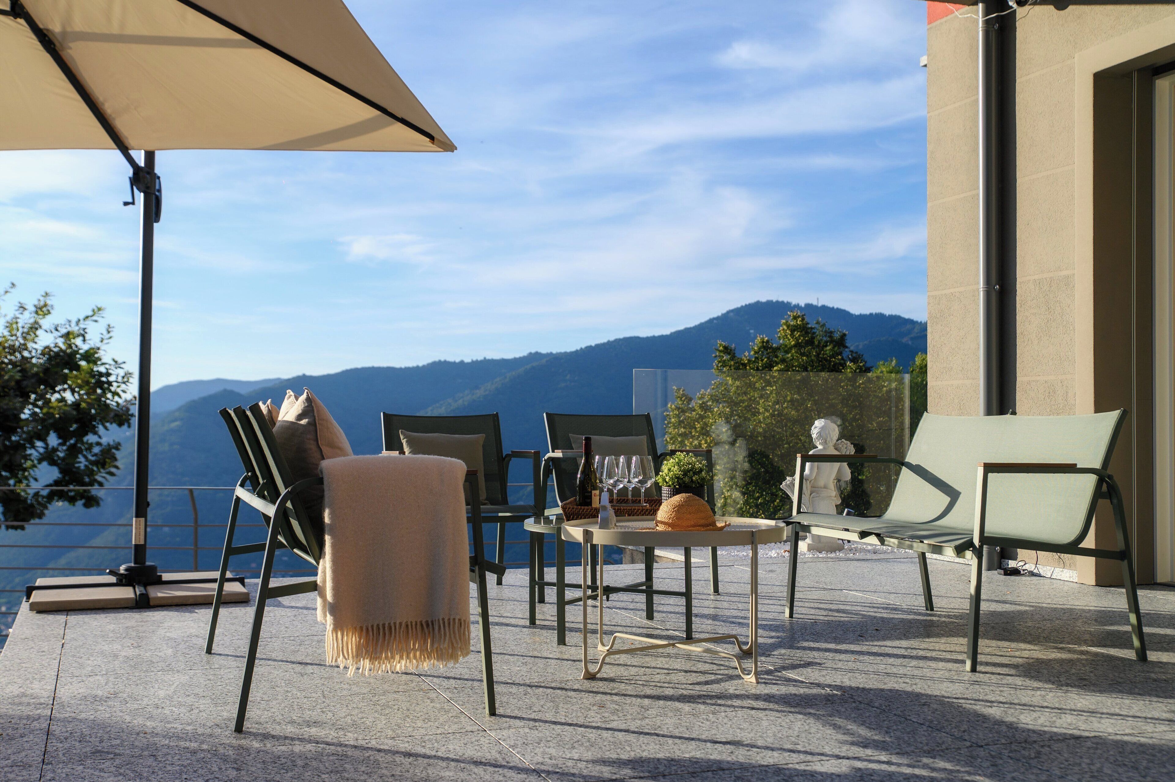 An outdoor seating area with a table, chairs, and a large umbrella.