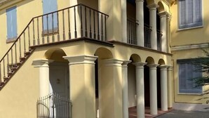 A two-story building with a balcony, columns, and a gated entrance. - B e B Villa Livia (Rolo)