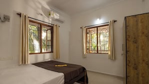 A room with two beds, a wardrobe, and two windows with curtains. - Cashew Garden Homestay (Agonda)