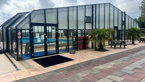 A greenhouse-style building with a pool visible through the glass doors. - Cozy chalet near the sea. Pet friendly! (Schagen)
