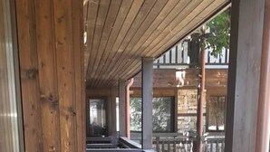 A covered wooden deck with a metal railing, leading to a stone building. - Relax in Banya's Hidden Gem - Igzila Appartment (Razlog)