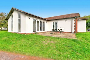 A two-story house with a patio, large windows, and a brick exterior. - Bright & Modern 2 Bed Holiday Chalet nr Sidmouth (Sidmouth)
