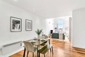 Un comedor moderno con una mesa de madera, sillas y un centro de mesa con planta.