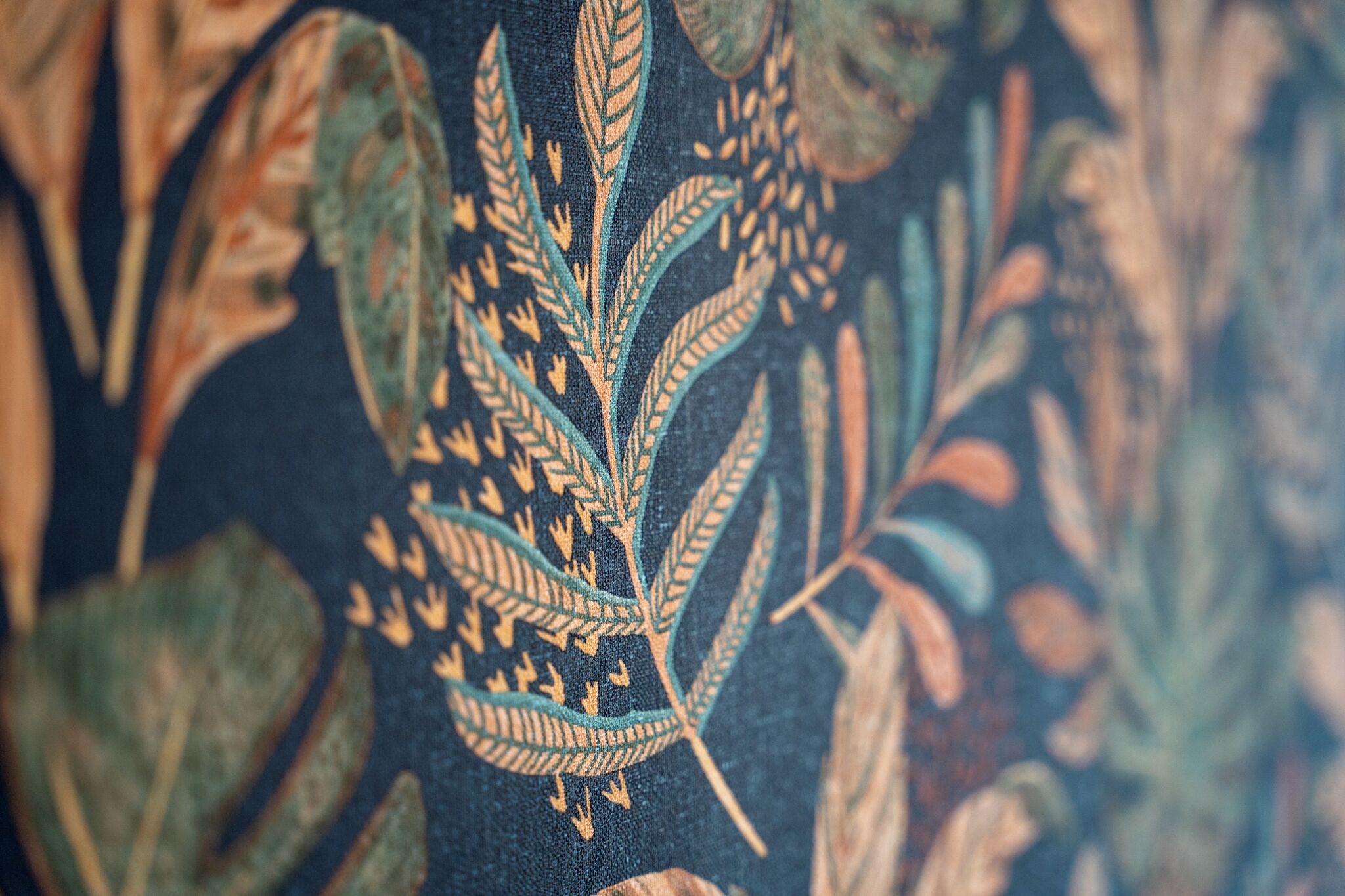 A close-up of a textile with a detailed leaf pattern.