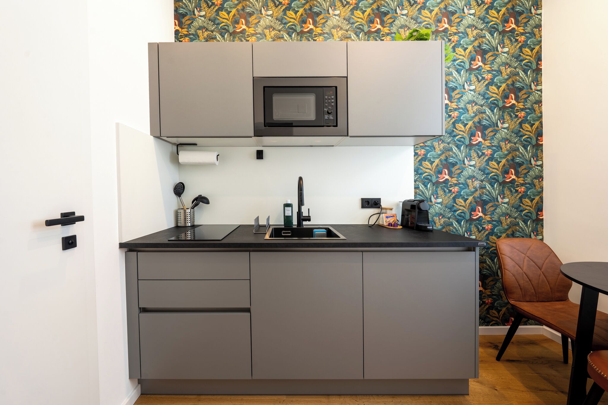 A compact kitchen with a microwave, sink, and a small countertop.